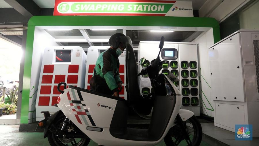 Pengemudi ojek daring mengganti baterai sepeda motor listriknya di stasiun pengisian baterai listrik (Swapping Station) di Kuningan, Jakarta, Senin (30/5/2022). (CNBC Indonesia/Andrean Kristianto)