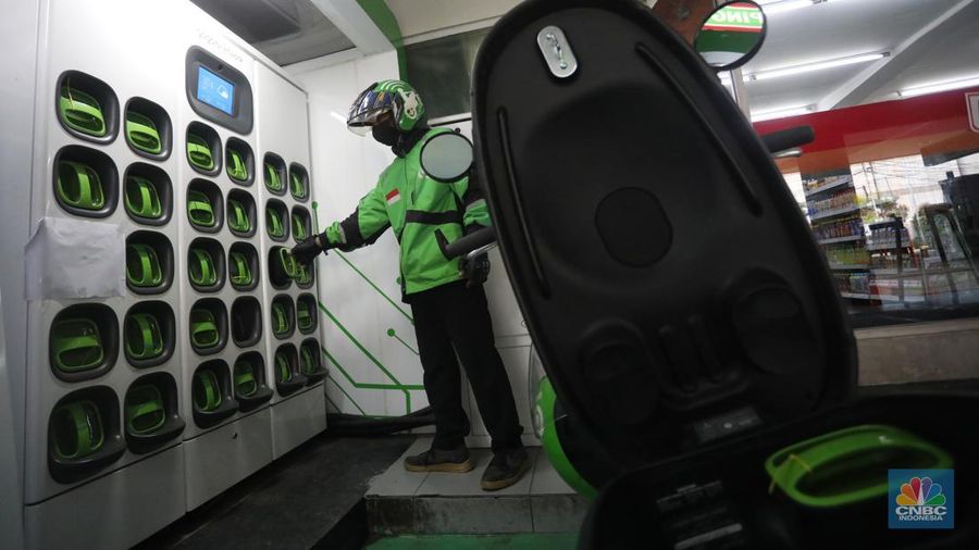 Pengemudi ojek daring mengganti baterai sepeda motor listriknya di stasiun pengisian baterai listrik (Swapping Station) di Kuningan, Jakarta, Senin (30/5/2022). (CNBC Indonesia/Andrean Kristianto)