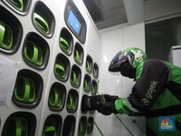Pengemudi ojek daring mengganti baterai sepeda motor listriknya di stasiun pengisian baterai listrik (Swapping Station) di Kuningan, Jakarta, Senin (30/5/2022). (CNBC Indonesia/Andrean Kristianto)