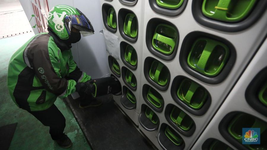 Pengemudi ojek daring mengganti baterai sepeda motor listriknya di stasiun pengisian baterai listrik (Swapping Station) di Kuningan, Jakarta, Senin (30/5/2022). (CNBC Indonesia/Andrean Kristianto)