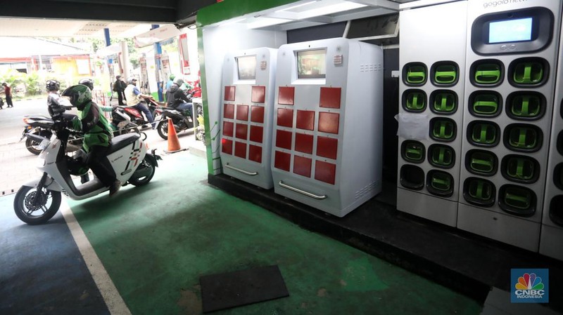 Pengemudi ojek daring mengganti baterai sepeda motor listriknya di stasiun pengisian baterai listrik (Swapping Station) di Kuningan, Jakarta, Senin (30/5/2022). (CNBC Indonesia/Andrean Kristianto)
