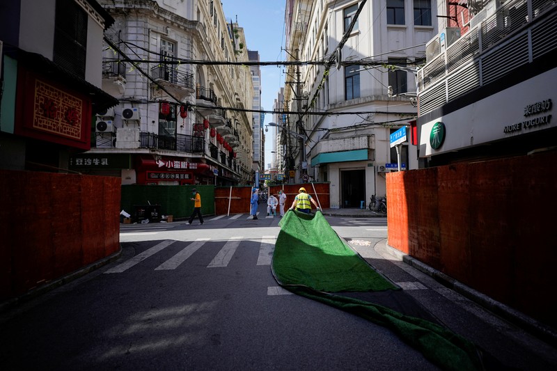 A worker dismantles barriers at a residential area, as the city prepares to end the lockdown placed to curb the coronavirus disease (COVID-19) outbreak in Shanghai, China May 31, 2022. REUTERS/Aly Song