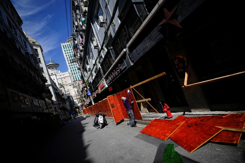 A worker dismantles barriers at a residential area, as the city prepares to end the lockdown placed to curb the coronavirus disease (COVID-19) outbreak in Shanghai, China May 31, 2022. REUTERS/Aly Song