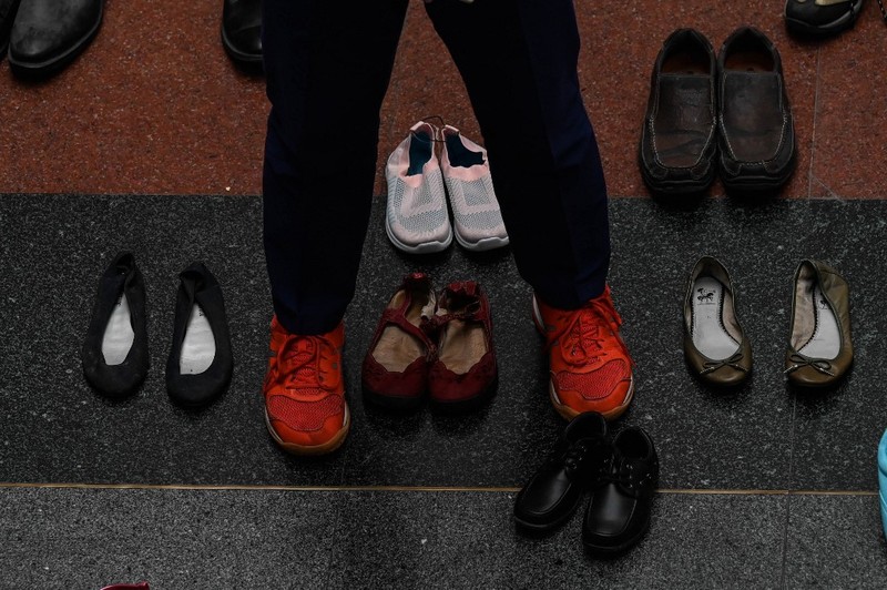 PHILIPPINES-HEALTH-TOBACCO A medical staff stands in between pairs of shoes, part of an art installation with 321 pairs of shoes that signifies the deaths caused by smoking, in observance to the World No Tobacco Day, at the Lung Center of the Philippines in Quezon City, suburban Manila on May 31, 2022. (Photo by JAM STA ROSA / AFP)
