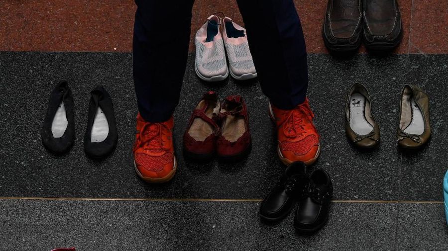 A medical staff stands in between pairs of shoes, part of an art installation with 321 pairs of shoes that signifies the deaths caused by smoking, in observance to the World No Tobacco Day, at the Lung Center of the Philippines in Quezon City, suburban Manila on May 31, 2022. (Photo by JAM STA ROSA / AFP)