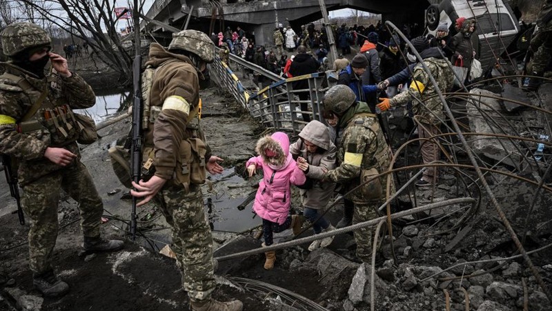 Seorang gadis berjalan di depan gedung apartemen yang rusak setelah serangan Rusia ke Ukraina di kota Slovyansk di wilayah Donbas, Ukraina timur, Selasa (31/5/2022). (Photo by ARIS MESSINIS / AFP)