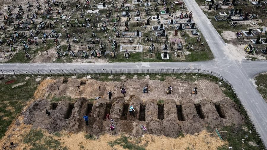 Seorang gadis berjalan di depan gedung apartemen yang rusak setelah serangan Rusia ke Ukraina di kota Slovyansk di wilayah Donbas, Ukraina timur, Selasa (31/5/2022). (Photo by ARIS MESSINIS / AFP)
