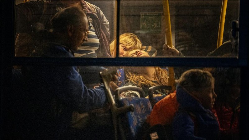 Seorang gadis berjalan di depan gedung apartemen yang rusak setelah serangan Rusia ke Ukraina di kota Slovyansk di wilayah Donbas, Ukraina timur, Selasa (31/5/2022). (Photo by ARIS MESSINIS / AFP)
