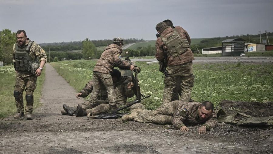 Seorang gadis berjalan di depan gedung apartemen yang rusak setelah serangan Rusia ke Ukraina di kota Slovyansk di wilayah Donbas, Ukraina timur, Selasa (31/5/2022). (Photo by ARIS MESSINIS / AFP)