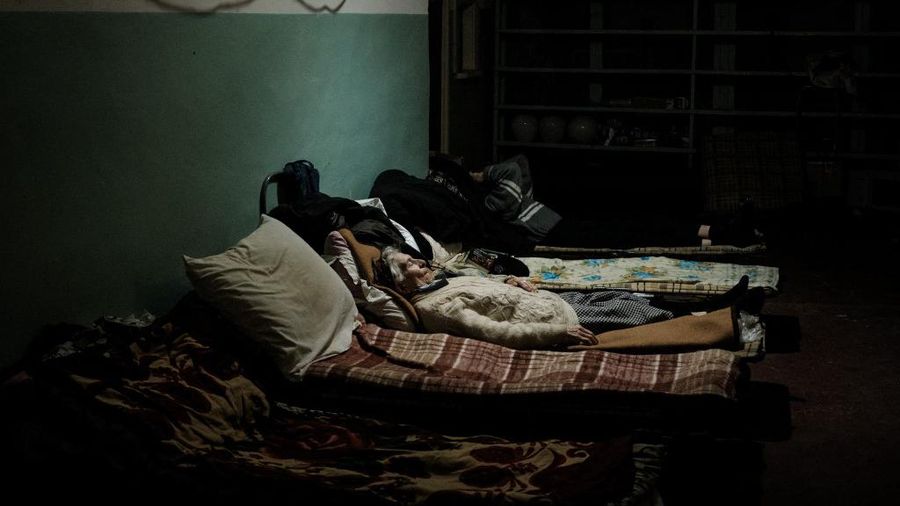 Seorang wanita berusia 85 tahun tidur di tempat tidurnya di bunker pabrik Ostchem di Severodonetsk, Ukraina timur, Rabu (27/4/2022) di tengah serangan militer Rusia ke Ukraina. (Photo by Yasuyoshi CHIBA / AFP)