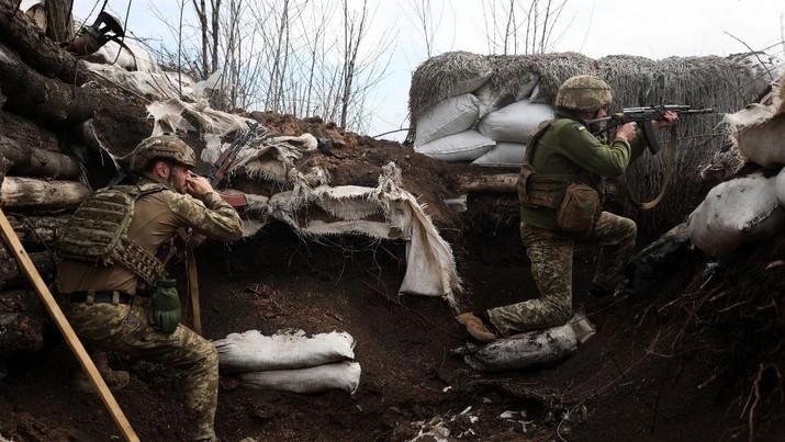 Tentara Ukraina menembak dengan senapan serbu di parit di garis depan dengan pasukan Rusia di wilayah Lugansk, Ukraina, Senin (11/4/2022).  (Photo by Anatolii STEPANOV / AFP)