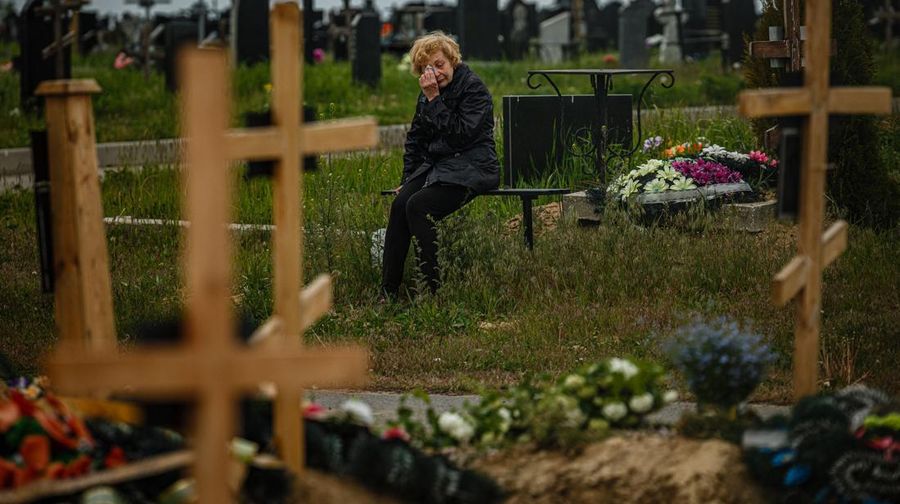 TOPSHOT - A woman mourns while visiting the grave of Stanislav Hvostov, 22, a Ukrainian serviceman killed during the Russian invasion of Ukraine, in the military section of the Kharkiv cemetery number 18 in Bezlioudivka, eastern Ukraine on May 21, 2022. (Photo by Dimitar DILKOFF / AFP) (Photo by DIMITAR DILKOFF/AFP via Getty Images)