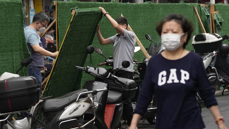Residents wearing masks visit Yu Garden Mall, Thursday, June 2, 2022, in Shanghai. Traffic, pedestrians and joggers reappeared on the streets of Shanghai on Wednesday as China's largest city began returning to normalcy amid the easing of a strict two-month COVID-19 lockdown that has drawn unusual protests over its heavy-handed implementation. (AP Photo/Ng Han Guan)