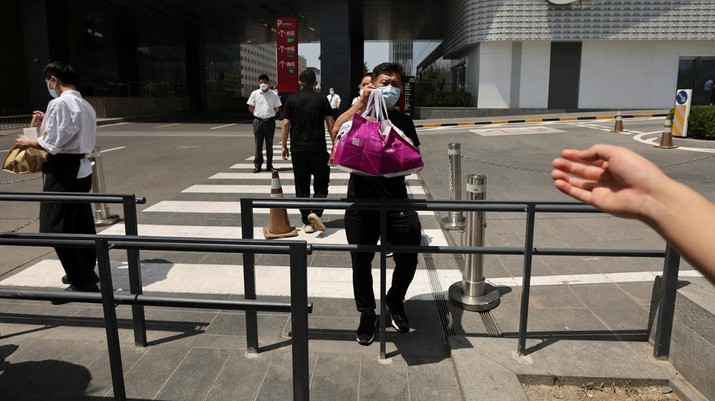 A restaurant staff member passes take-away parcels to a delivery worker during lunch hour, following a ban on dine-in services amid the coronavirus disease (COVID-19) outbreak, in the Central Business District (CBD) of Beijing, China June 2, 2022. REUTERS/Tingshu Wang