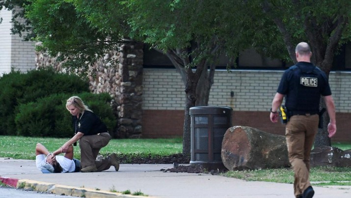 A police officer consoles a person at the family reunion location, Memorial High School, after a shooting at the Saint Francis hospital campus, in Tulsa, Oklahoma, June 1, 2022.   REUTERS/Michael Noble Jr.