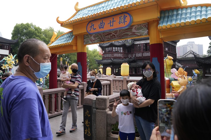 Residents wearing masks visit Yu Garden Mall, Thursday, June 2, 2022, in Shanghai. Traffic, pedestrians and joggers reappeared on the streets of Shanghai on Wednesday as China's largest city began returning to normalcy amid the easing of a strict two-month COVID-19 lockdown that has drawn unusual protests over its heavy-handed implementation. (AP Photo/Ng Han Guan)