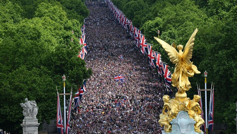 Members of the public fill The Mall ahead of a flypast over Buckingham Palace, during the Trooping the Color in London, Thursday, June 2, 2022, on the first of four days of celebrations to mark the Platinum Jubilee. The events over a long holiday weekend in the U.K. are meant to celebrate the monarch's 70 years of service. (Paul Ellis/Pool Photo via AP)