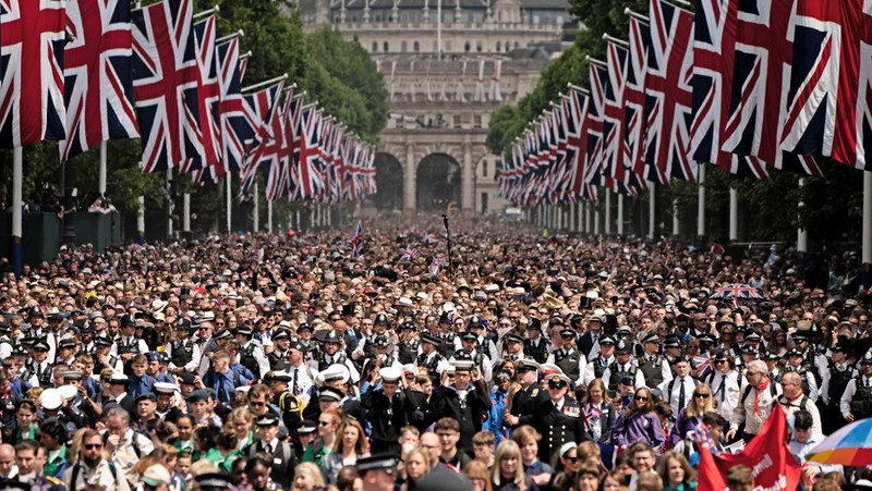 Members of the public fill The Mall ahead of a flypast over Buckingham Palace, during the Trooping the Color in London, Thursday, June 2, 2022, on the first of four days of celebrations to mark the Platinum Jubilee. The events over a long holiday weekend in the U.K. are meant to celebrate the monarch's 70 years of service. (Paul Ellis/Pool Photo via AP)