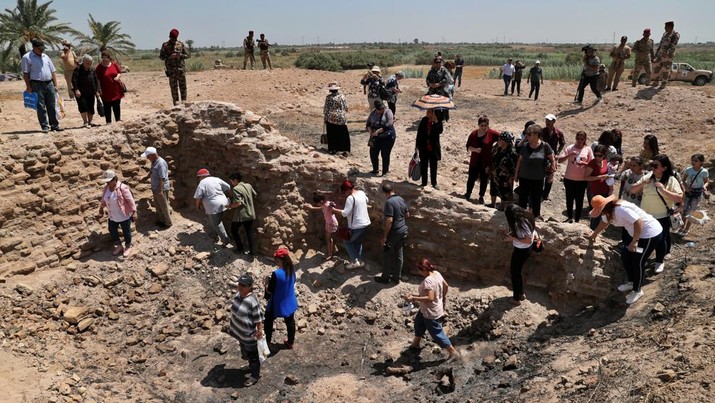 Iraqi Christians survey the archaeological site of Kokheh Church south of Baghdad, Iraq, Friday, Aug 23, 2019. The historical church located on the left bank of the Tigris River some 20 miles south of the capital Baghdad dates back to the first century AD. Remnants of the church, an archaeological site and one of the most important sites of Eastern Christianity, was reopened again to the public last year after a years-long closure due to security concerns. (AP Photo/Khalid Mohammed)