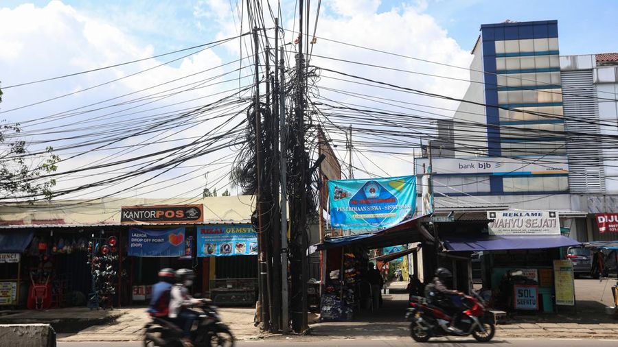 Kendaraan melintas di samping kabel yang semrawut di kawasan jalan Raya Bogor, Kramat Jati, Jakarta Timur, Jumat (3/6/2022). (²©²ÊÍøÕ¾/ Andrean Kristianto)