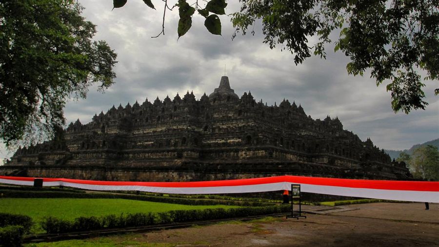 Bendera merah putih sepanjang 1.000 meter dengan latar belakang Candi Borobudur dibentangkan saat parade peringatan Hari Pancasila di Magelang, Jawa Tengah, Rabu (1/6/2022). (Photo by DEVI RAHMAN / AFP) (Photo by DEVI RAHMAN/AFP via Getty Images)