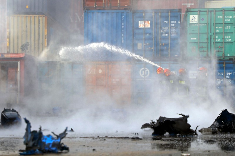 Kebakaran di Depot Kontainer Bangladesh Petugas pemadam kebakaran berusaha memadamkan api yang berkobar di fasilitas penyimpanan peti kemas di Sitakunda, sekitar 40 km (25 mil) dari pelabuhan utama Chittagong, Bangladesh, Minggu (5/6/2022). Insiden ini menewaskan sedikitnya 16 orang dan melukai lebih dari 150 orang. (Photo by -/AFP via Getty Images)