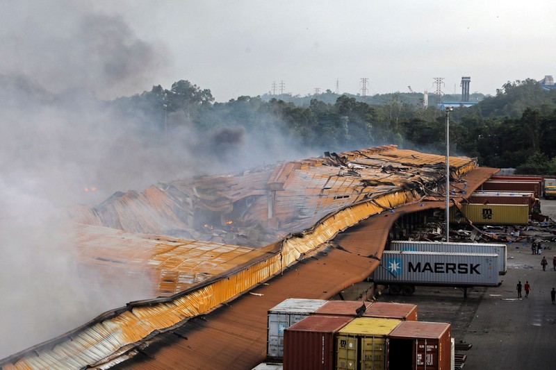 Kebakaran di Depot Kontainer Bangladesh Petugas pemadam kebakaran berusaha memadamkan api yang berkobar di fasilitas penyimpanan peti kemas di Sitakunda, sekitar 40 km (25 mil) dari pelabuhan utama Chittagong, Bangladesh, Minggu (5/6/2022). Insiden ini menewaskan sedikitnya 16 orang dan melukai lebih dari 150 orang. (Photo by -/AFP via Getty Images)