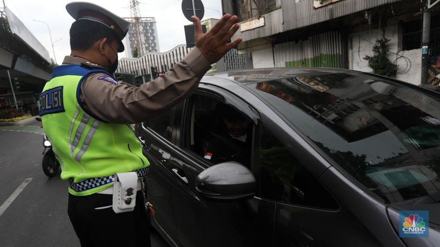 Sejumlah polisi lalulintas memberhentikan pengendara mobil yang melanggar peraturan lalu lintas saat pemberlakuan aturan ganjil genap di kawasan Kramat Raya, Jakarta, Senin (6/6/2022). (CNBC Indonesia/Andrean Kristianto)