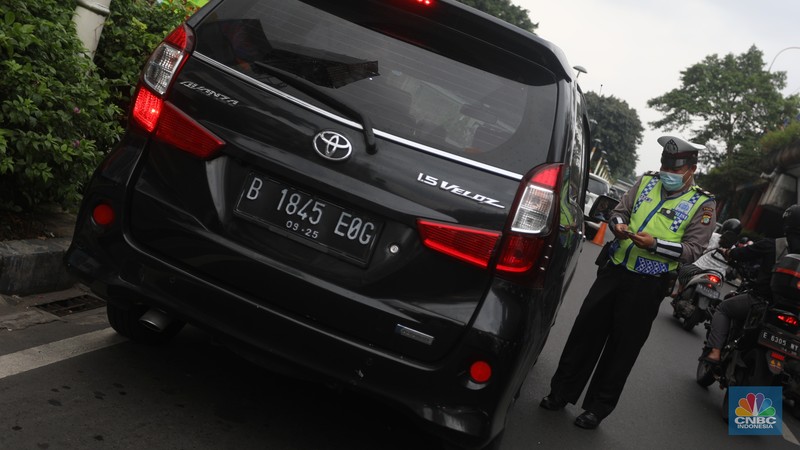 Sejumlah polisi lalulintas memberhentikan pengendara mobil yang melanggar peraturan lalu lintas saat pemberlakuan aturan ganjil genap di kawasan Kramat Raya, Jakarta, Senin (6/6/2022). (CNBC Indonesia/Andrean Kristianto)
