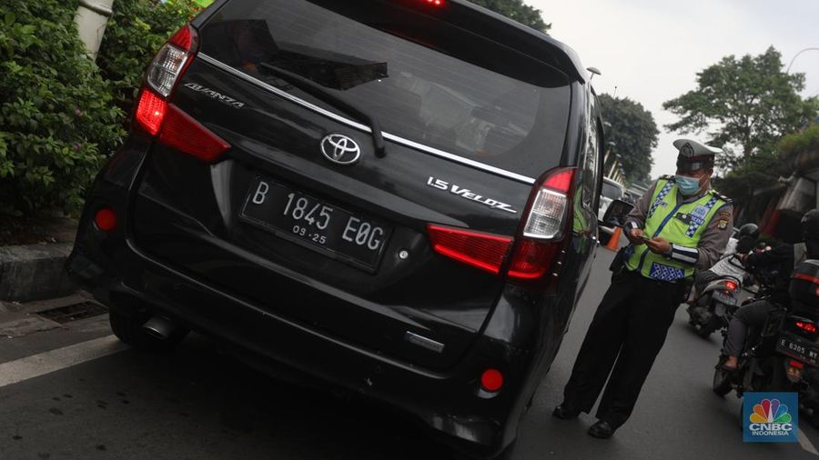 Sejumlah polisi lalulintas memberhentikan pengendara mobil yang melanggar peraturan lalu lintas saat pemberlakuan aturan ganjil genap di kawasan Kramat Raya, Jakarta, Senin (6/6/2022). (CNBC Indonesia/Andrean Kristianto)