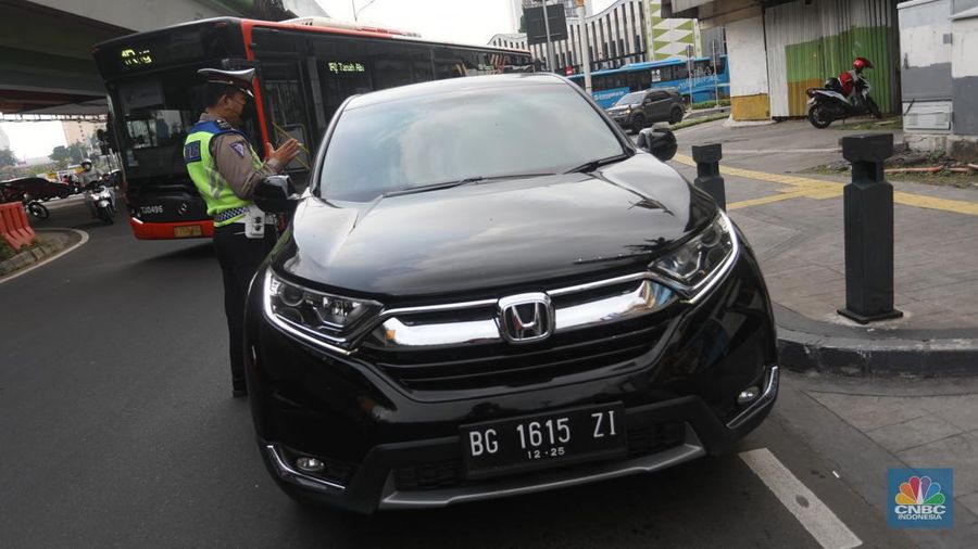 Sejumlah polisi lalulintas memberhentikan pengendara mobil yang melanggar peraturan lalu lintas saat pemberlakuan aturan ganjil genap di kawasan Kramat Raya, Jakarta, Senin (6/6/2022). (CNBC Indonesia/Andrean Kristianto)