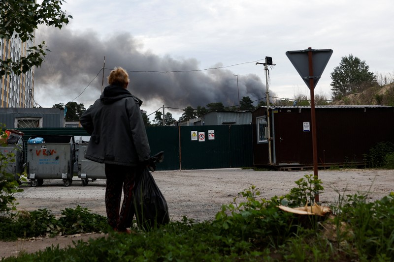 Seorang pria melihat asap setelah ledakan terdengar saat serangan Rusia di Ukraina berlanjut, di Kyiv, Ukraina 5 Juni 2022. (REUTERS/EDGAR SU)