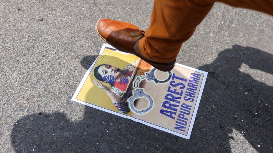 Seorang demonstran menginjak poster anggota Partai Bharatiya Janata (BJP) Nupur Sharma selama protes setelah komentarnya yang menghujat Nabi Muhammad, di sebuah jalan di Mumbai, India, 6 Juni 2022. (REUTERS/FRANCIS MASCARENHAS)