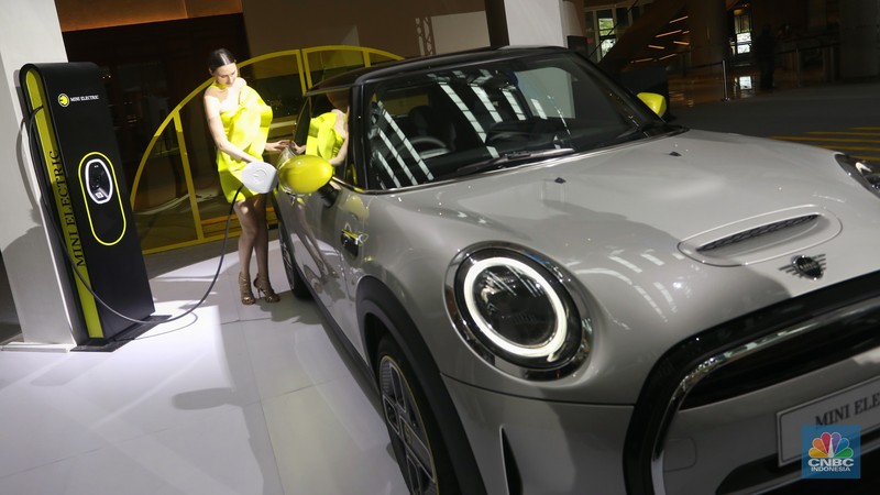 Model berpose di depan mobil MINI Electric Collection  yang baru diluncurkan di Jakarta, Rabu (8/6/2022). (CNBC Indonesia/Andrean Kristianto)