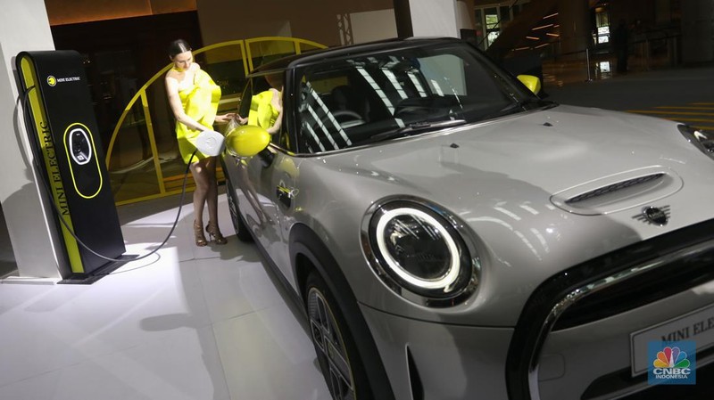 Model berpose di depan mobil MINI Electric Collection  yang baru diluncurkan di Jakarta, Rabu (8/6/2022). (CNBC Indonesia/Andrean Kristianto)