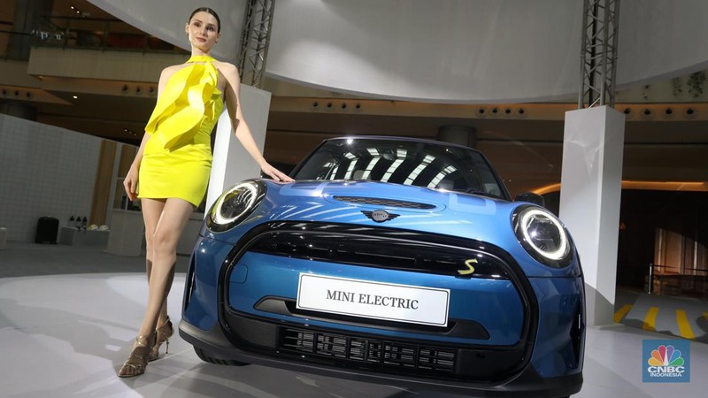 Model berpose di depan mobil MINI Electric Collection  yang baru diluncurkan di Jakarta, Rabu (8/6/2022). (CNBC Indonesia/Andrean Kristianto)