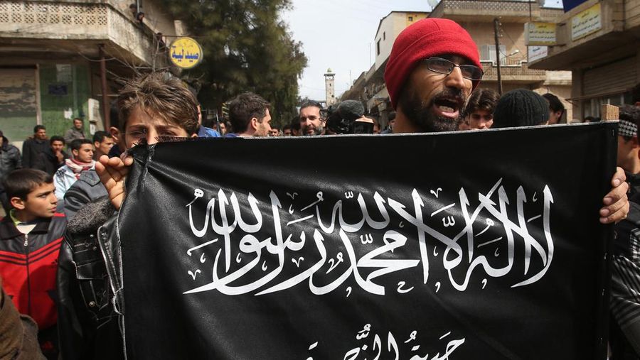 Pengunjuk rasa anti-Presiden Suriah Bashar Assad memegang bendera Jabhat al-Nusra, saat mereka meneriakkan slogan-slogan selama demonstrasi, di Kafranbel, provinsi Idlib, Suriah utara. (AP/Hussein Malla)