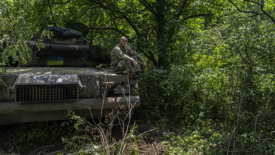 Seorang prajurit Ukraina merokok di atas APC saat istirahat di dekat garis depan di wilayah Donetsk, Ukraina timur, Senin, 6 Juni 2022. (AP/Bernat Armangue)
