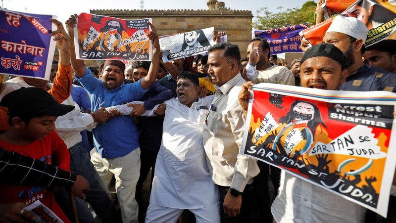 Pendukung kelompok agama Tehreek-e-Hurmat-e-Rasool membakar representasi bendera India selama demonstrasi untuk mengutuk referensi menghina Islam dan Nabi Muhammad yang dibuat baru-baru ini oleh Nupur Sharma, juru bicara partai nasionalis Hindu India yang memerintah di Lahore, Pakistan. (AP/K.M. Chaudary)