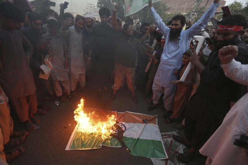 Pendukung kelompok agama Tehreek-e-Hurmat-e-Rasool membakar representasi bendera India selama demonstrasi untuk mengutuk referensi menghina Islam dan Nabi Muhammad yang dibuat baru-baru ini oleh Nupur Sharma, juru bicara partai nasionalis Hindu India yang memerintah di Lahore, Pakistan. (AP/K.M. Chaudary) Pendukung kelompok agama Tehreek-e-Hurmat-e-Rasool membakar representasi bendera India selama demonstrasi untuk mengutuk referensi menghina Islam dan Nabi Muhammad yang dibuat baru-baru ini oleh Nupur Sharma, juru bicara partai nasionalis Hindu India yang memerintah di Lahore, Pakistan. (AP/K.M. Chaudary)