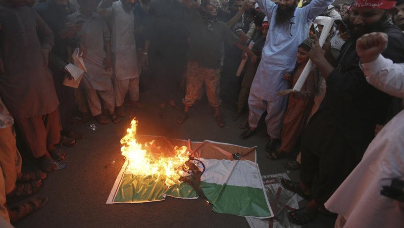 Pendukung kelompok agama Tehreek-e-Hurmat-e-Rasool membakar representasi bendera India selama demonstrasi untuk mengutuk referensi menghina Islam dan Nabi Muhammad yang dibuat baru-baru ini oleh Nupur Sharma, juru bicara partai nasionalis Hindu India yang memerintah di Lahore, Pakistan. (AP/K.M. Chaudary)