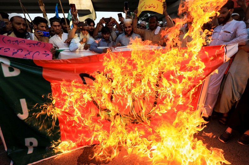 Pendukung kelompok agama Tehreek-e-Hurmat-e-Rasool membakar representasi bendera India selama demonstrasi untuk mengutuk referensi menghina Islam dan Nabi Muhammad yang dibuat baru-baru ini oleh Nupur Sharma, juru bicara partai nasionalis Hindu India yang memerintah di Lahore, Pakistan. (AP/K.M. Chaudary) Pendukung kelompok agama Tehreek-e-Hurmat-e-Rasool membakar representasi bendera India selama demonstrasi untuk mengutuk referensi menghina Islam dan Nabi Muhammad yang dibuat baru-baru ini oleh Nupur Sharma, juru bicara partai nasionalis Hindu India yang memerintah di Lahore, Pakistan. (AP/K.M. Chaudary)