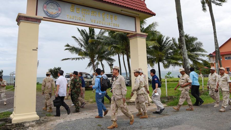 Personel angkatan laut Kamboja berjalan di sebuah dermaga di pangkalan angkatan laut Ream di provinsi Preah Sihanouk (AFP via Getty Images/TANG CHHIN SOTHY)