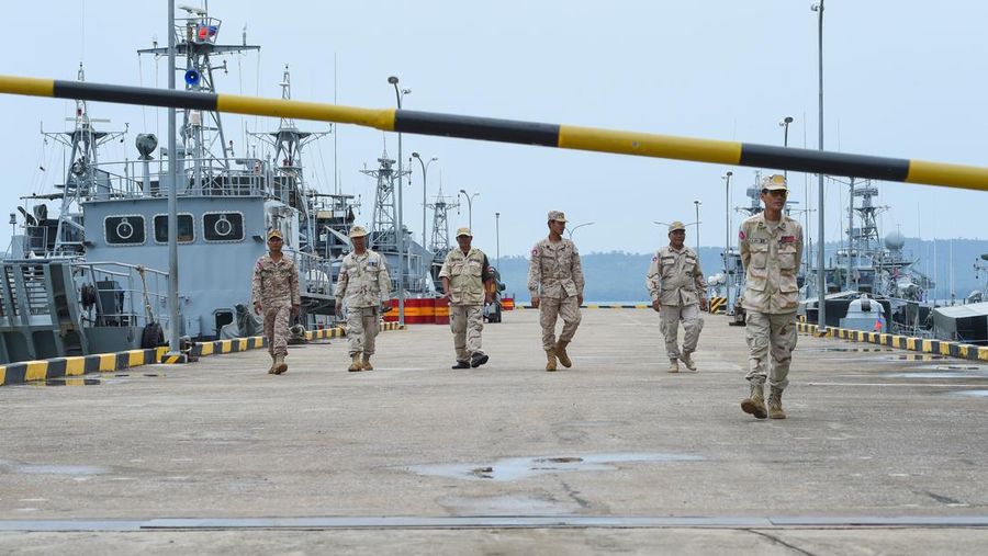 Personel angkatan laut Kamboja berjalan di sebuah dermaga di pangkalan angkatan laut Ream di provinsi Preah Sihanouk (AFP via Getty Images/TANG CHHIN SOTHY)