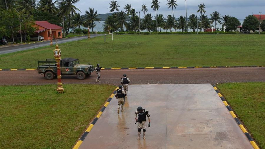 Personel angkatan laut Kamboja berjalan di sebuah dermaga di pangkalan angkatan laut Ream di provinsi Preah Sihanouk (AFP via Getty Images/TANG CHHIN SOTHY)