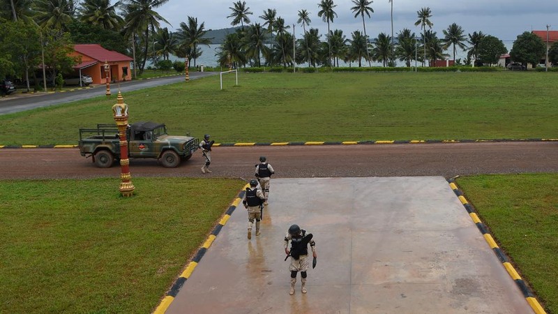 Personel angkatan laut Kamboja berjalan di sebuah dermaga di pangkalan angkatan laut Ream di provinsi Preah Sihanouk (AFP via Getty Images/TANG CHHIN SOTHY)