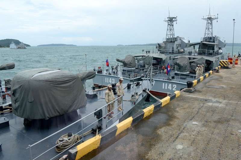 Personel angkatan laut Kamboja berjalan di sebuah dermaga di pangkalan angkatan laut Ream di provinsi Preah Sihanouk (AFP via Getty Images/TANG CHHIN SOTHY)