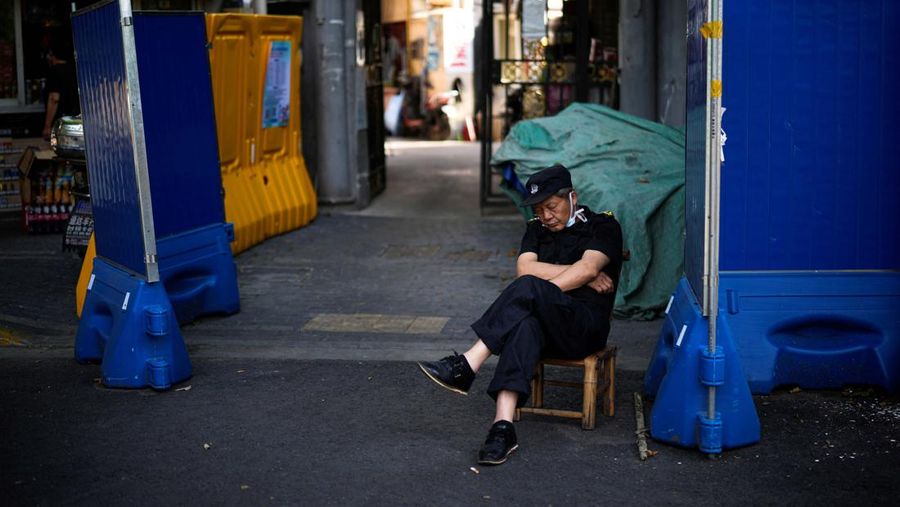 Seorang penjaga keamanan tidur siang di daerah perumahan, setelah penguncian yang dilakukan untuk mengekang wabah penyakit coronavirus (COVID-19) dicabut di Shanghai, Cina. (REUTERS/ALY SONG)