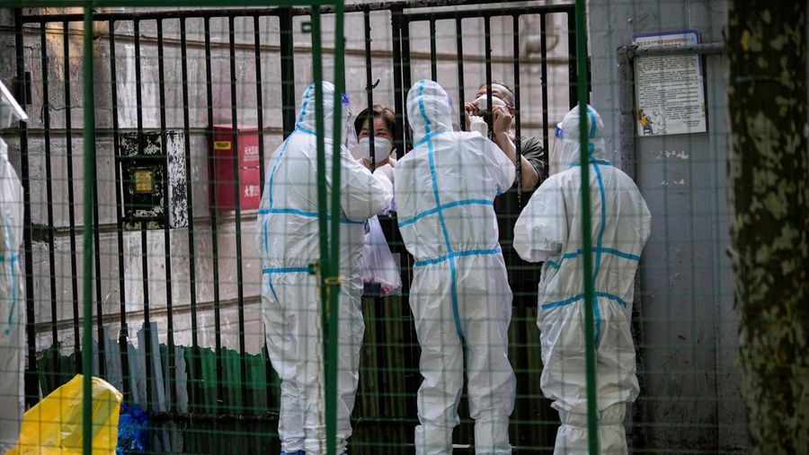 Seorang warga dites untuk penyakit virus corona (COVID-19) di balik penghalang area tertutup, setelah penguncian yang dilakukan untuk mengekang wabah COVID-19 dicabut di Shanghai, Cina, 8 Juni 2022. (REUTERS/ALY SONG)