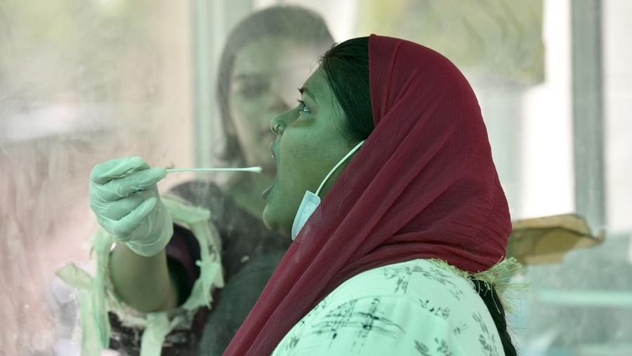 Seorang petugas kesehatan mengambil sampel swab untuk tes Covid-19 di Rumah Sakit Distrik Sektor 30, pada 8 Juni 2022 di Noida, India. (Hindustan Times via Getty Images/Hindustan Times)